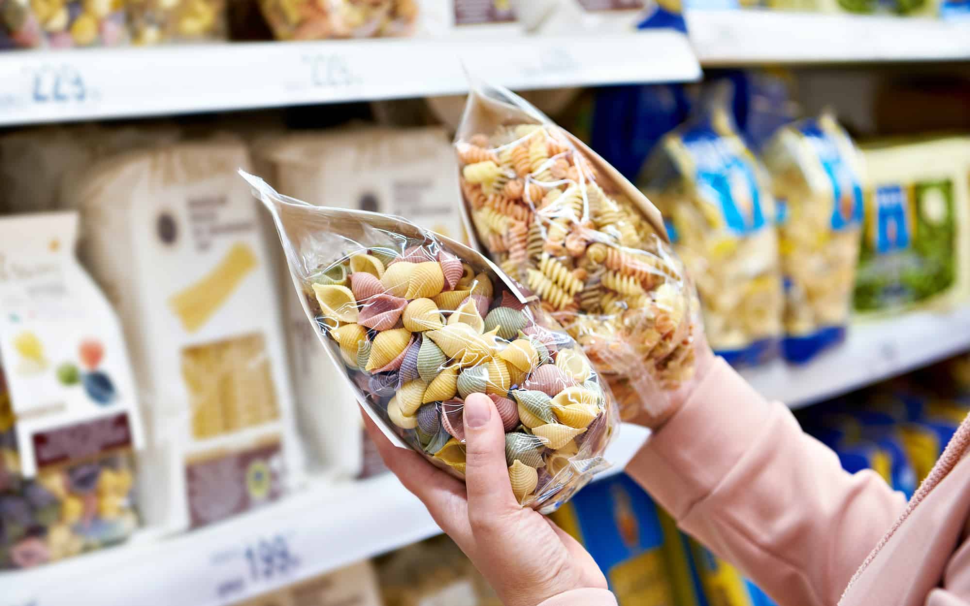 Woman Holding Packages of brand name Pasta at grocery store