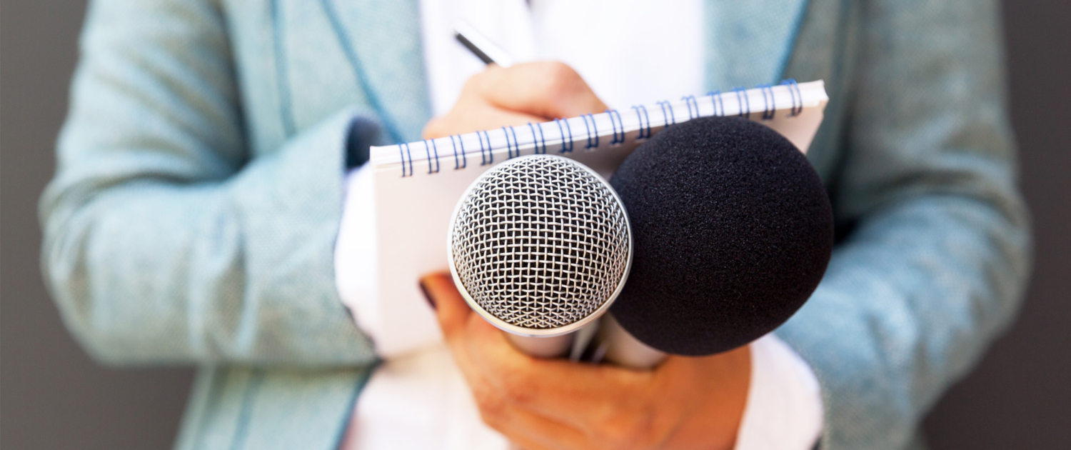 public relations journalist with microphone and note pad
