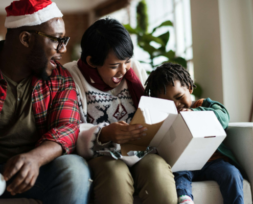 Happy family smiling and opening gifts together.