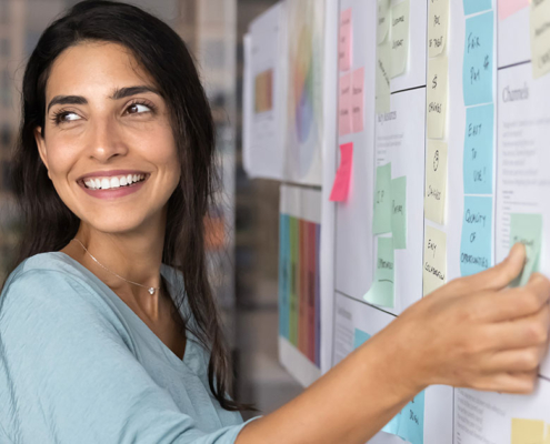 smiling woman in corporate office brainstorming public relations strategy for client
