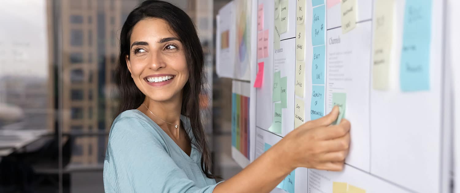 smiling woman in corporate office brainstorming public relations strategy for client