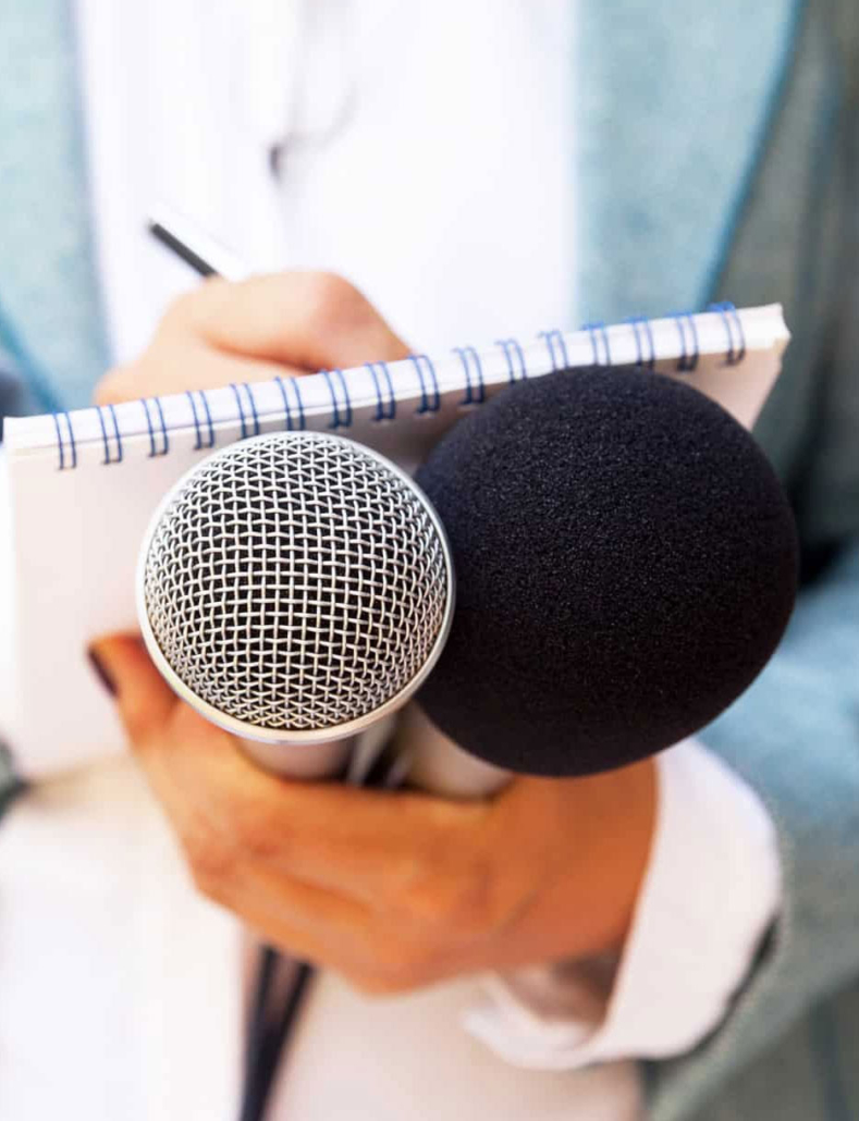 public relations journalist with microphone and note pad