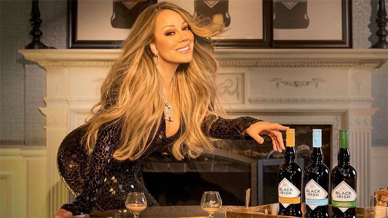 Mariah Carey posing with her 3 flavors of Black Irish premium Irish cream liqueur line
