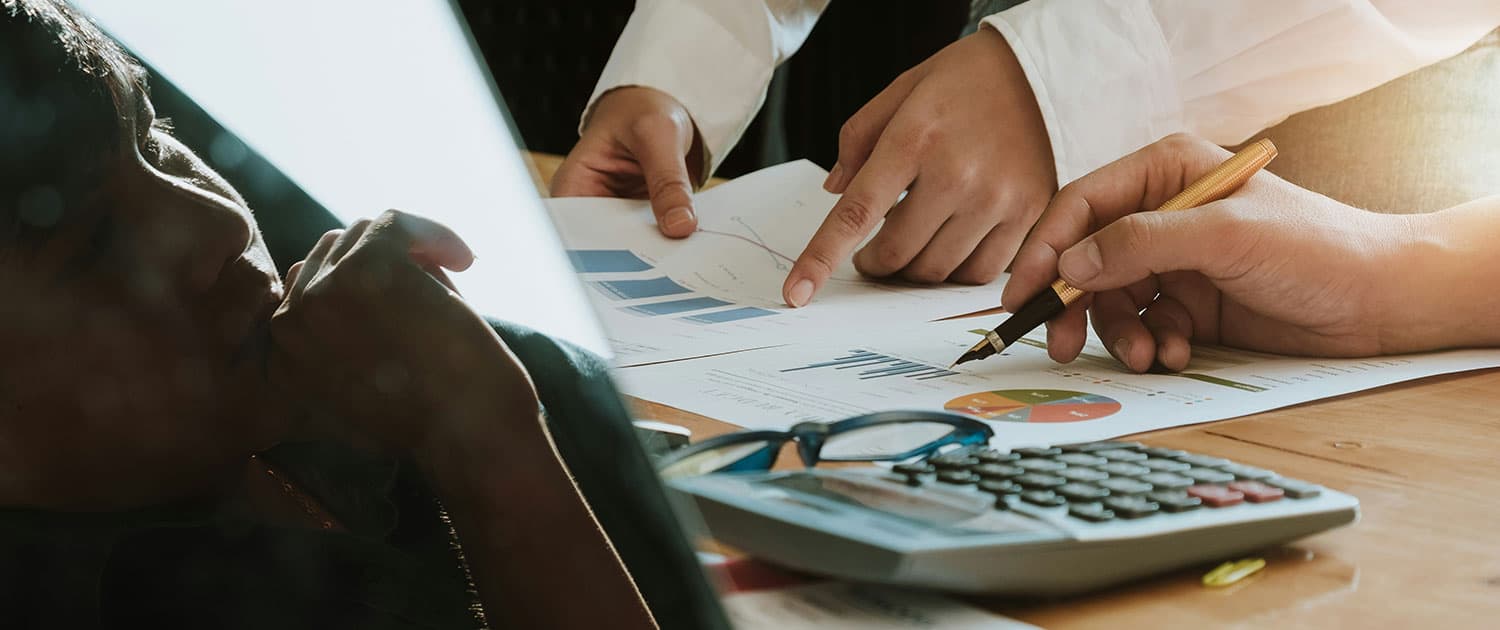 pr professionals looking through marketing analytics on paper together