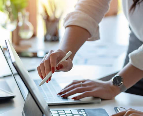 2 people at pr agency working on laptop to come up with marketing strategy