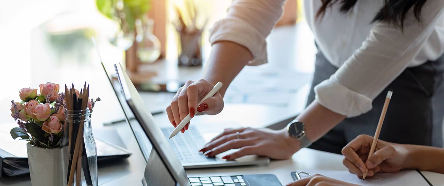 2 people at pr agency working on laptop to come up with marketing strategy