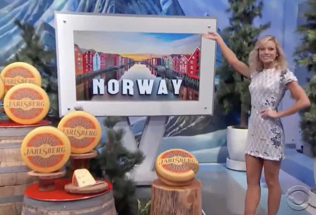 jarlsberg cheese wheels on Price is Right game show, with tv screen displaying 'Norway' and woman presenting