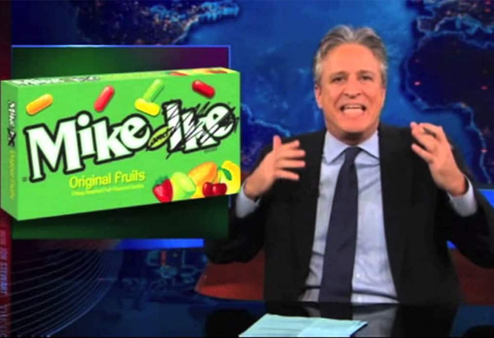 Jon Stewart displaying box of Mike and Ike's cany with 'Ike' scribbled out with marker, on Daily Show