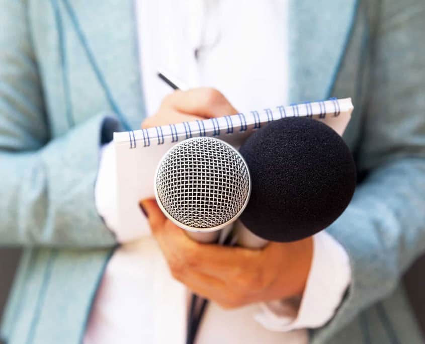 public relations journalist with microphone and note pad