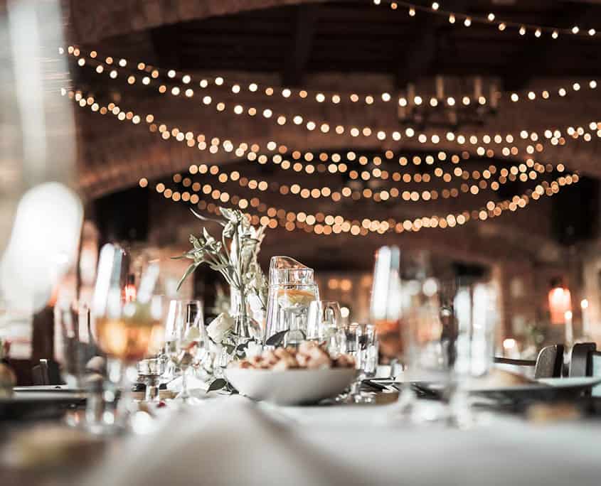 special event space with beautifully-dressed tables and hanging lights