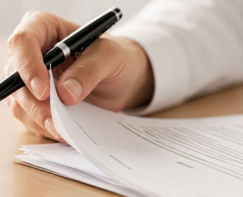 pr professional holding pen and reviewing documents at desk